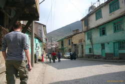 Jared walking down an old town street, complete with wattle and daub houses